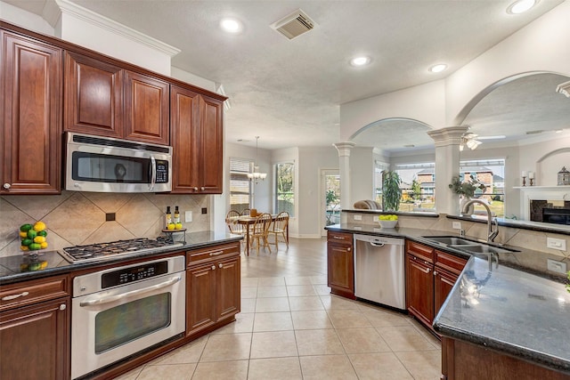 kitchen with light tile patterned floors, tasteful backsplash, visible vents, stainless steel appliances, and a sink