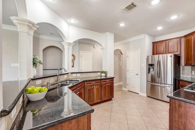 kitchen with light tile patterned floors, stainless steel appliances, a sink, visible vents, and tasteful backsplash