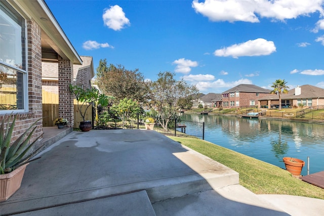 exterior space featuring a water view, fence, and a residential view