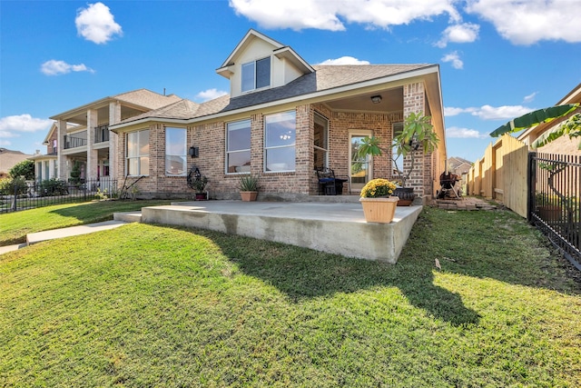 view of front facade featuring a fenced backyard, a patio, brick siding, and a front lawn