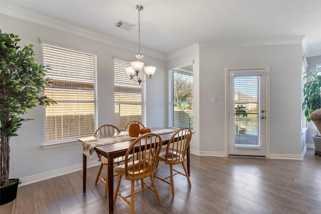 dining area featuring visible vents, crown molding, baseboards, and wood finished floors