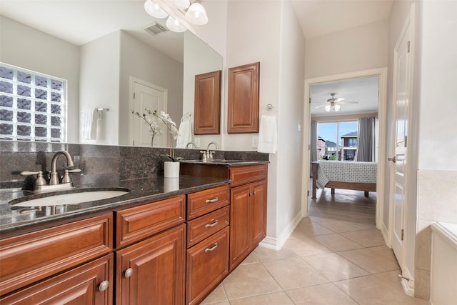 bathroom with double vanity, visible vents, ensuite bathroom, a sink, and tile patterned flooring