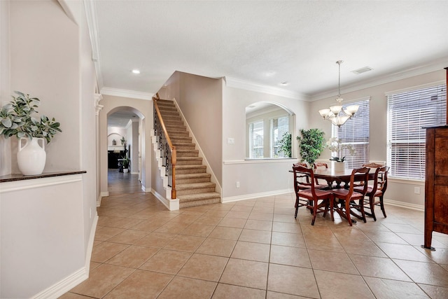 dining space with arched walkways, visible vents, crown molding, and light tile patterned floors