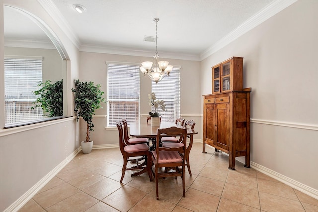 dining space with a chandelier, ornamental molding, light tile patterned floors, and baseboards