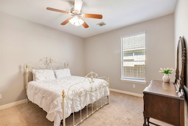 carpeted bedroom featuring visible vents, ceiling fan, and baseboards