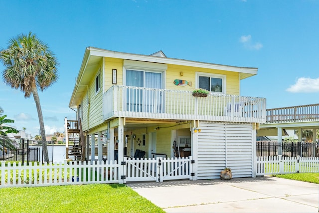 view of front of house with a carport, stairway, a fenced front yard, and a gate