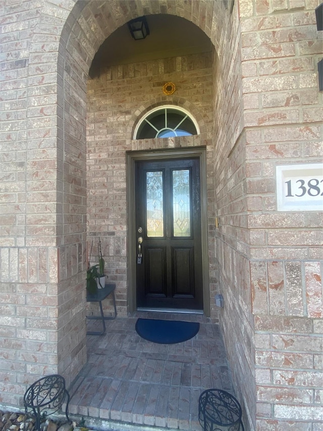 property entrance featuring brick siding