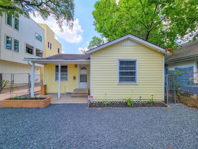 view of front of house with entry steps, fence, and a gate