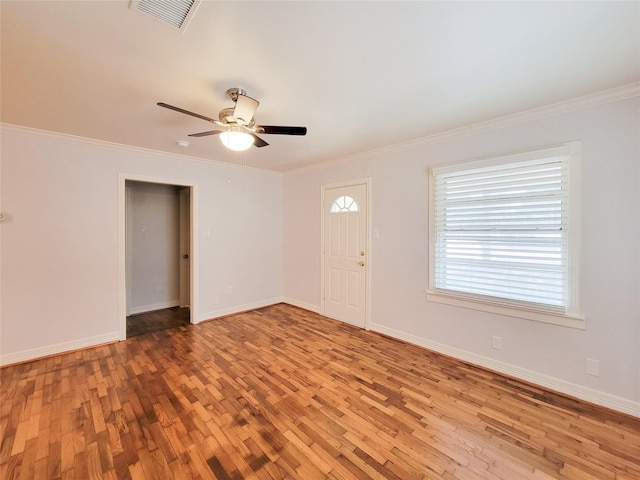 entryway featuring baseboards, visible vents, light wood-style flooring, ceiling fan, and ornamental molding