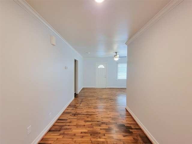 corridor featuring crown molding, baseboards, and wood finished floors