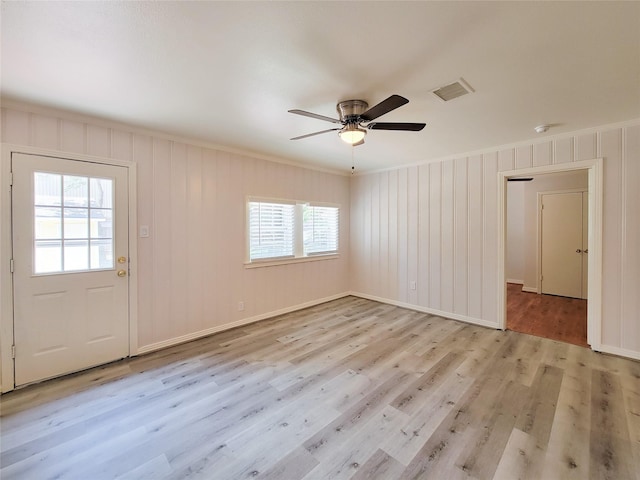 interior space with ceiling fan, visible vents, light wood-style flooring, and crown molding