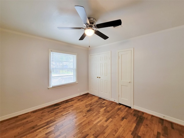 unfurnished bedroom with baseboards, wood finished floors, a ceiling fan, and ornamental molding