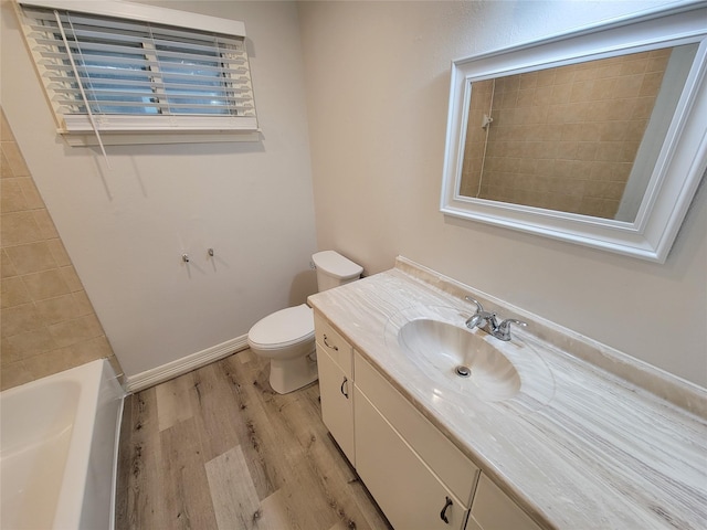 full bath with toilet, vanity, baseboards, and wood finished floors