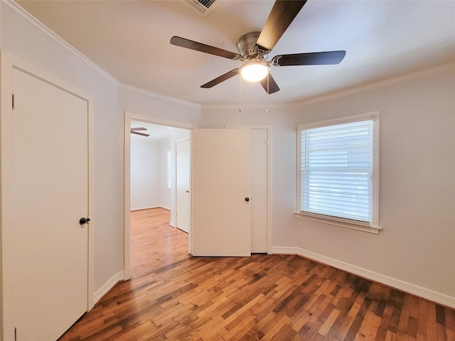 unfurnished bedroom with light wood-style floors, baseboards, and ornamental molding