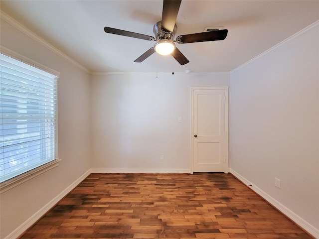 empty room featuring visible vents, ornamental molding, baseboards, and wood finished floors