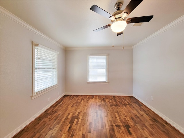 unfurnished room featuring a wealth of natural light, a ceiling fan, wood finished floors, and crown molding