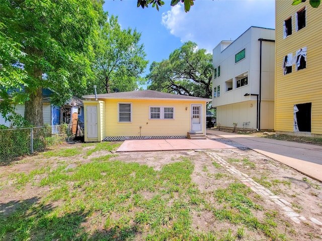 back of property featuring entry steps and fence