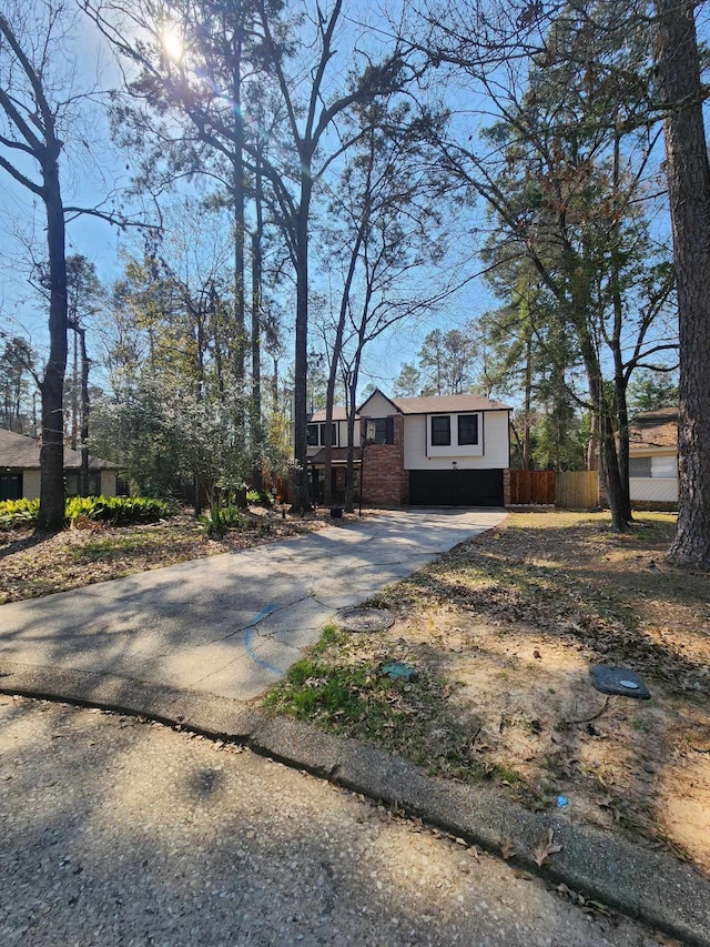 single story home featuring brick siding, driveway, and fence