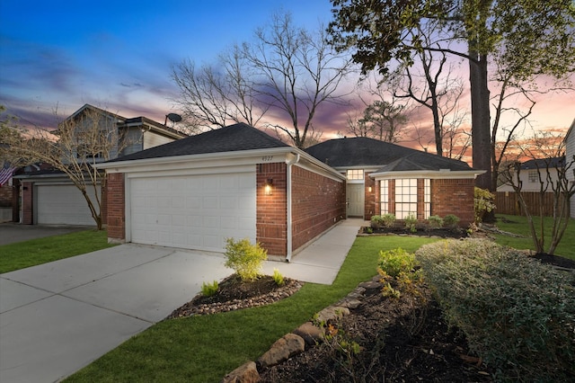 view of front facade featuring a garage, brick siding, driveway, and fence