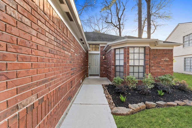 entrance to property featuring brick siding