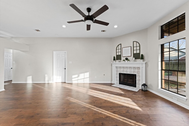 unfurnished living room featuring wood-type flooring, a tile fireplace, visible vents, and recessed lighting