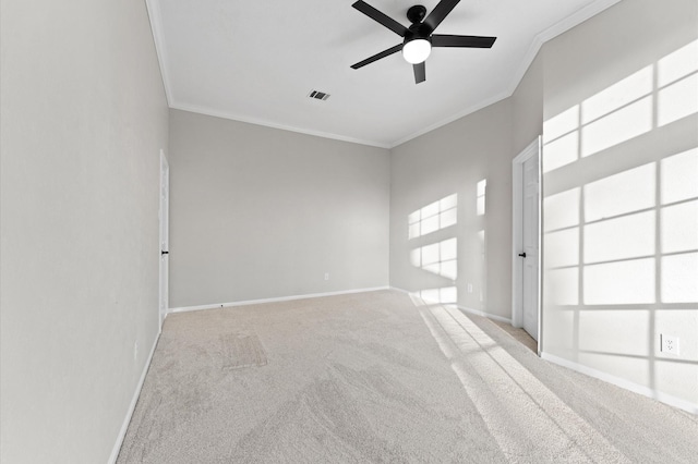 carpeted spare room featuring ornamental molding, a ceiling fan, visible vents, and baseboards