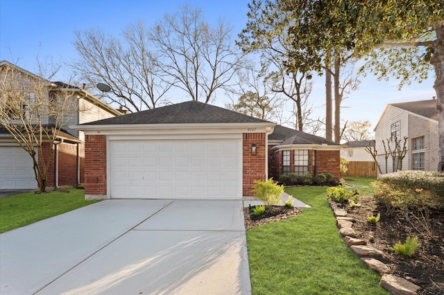 view of front facade featuring driveway, fence, a front lawn, and brick siding