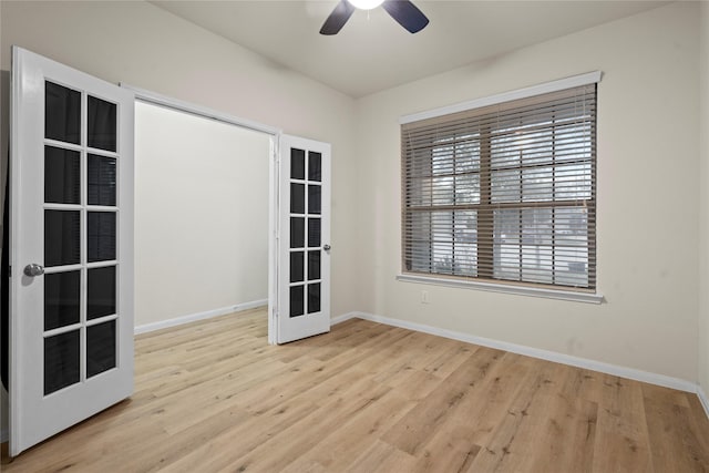 unfurnished room with ceiling fan, baseboards, wood finished floors, and french doors