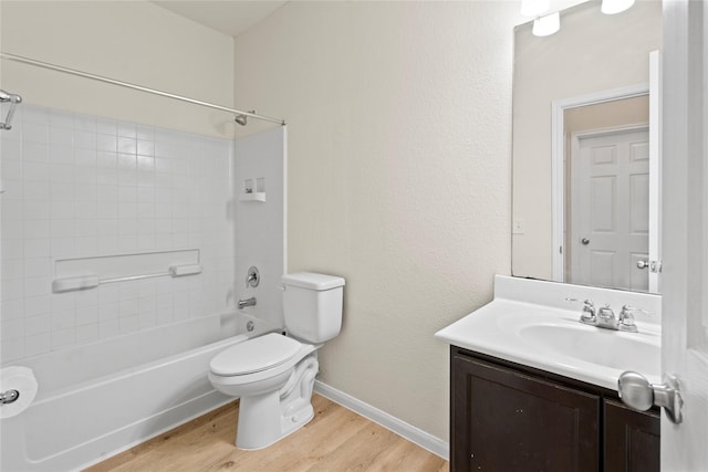 bathroom with toilet, wood finished floors, vanity, baseboards, and shower / bathing tub combination