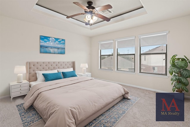 carpeted bedroom featuring ceiling fan, a raised ceiling, visible vents, and baseboards