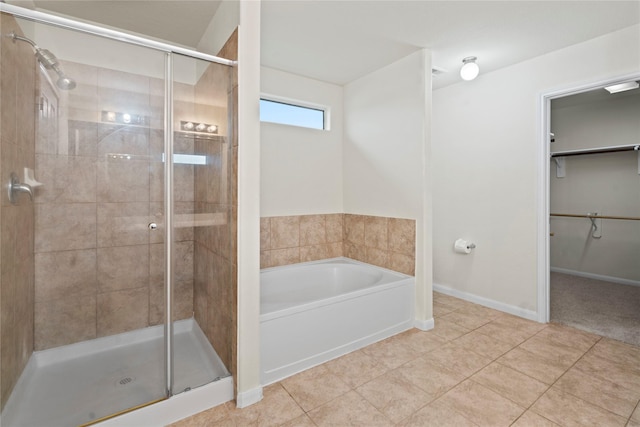 full bath featuring a garden tub, tile patterned flooring, baseboards, a spacious closet, and a shower stall