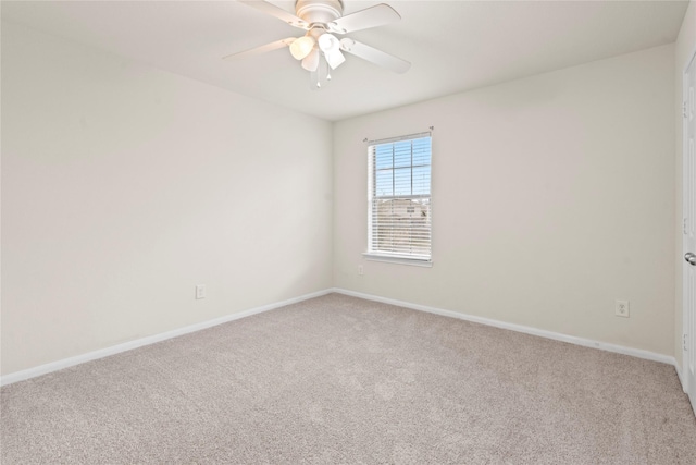 carpeted spare room featuring ceiling fan and baseboards