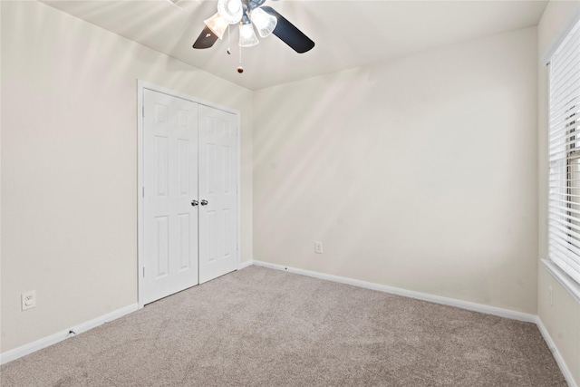 unfurnished bedroom featuring a ceiling fan, a closet, baseboards, and carpet flooring