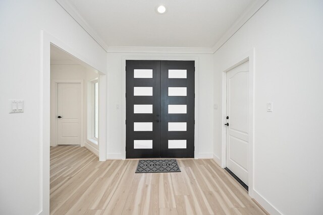 entrance foyer featuring crown molding, french doors, and light wood-style floors