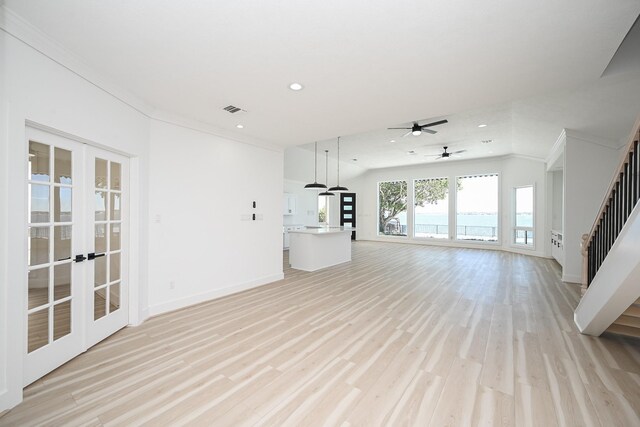 unfurnished living room with light wood finished floors, french doors, stairway, and recessed lighting