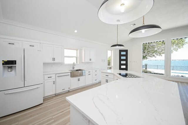 kitchen featuring white appliances, crown molding, white cabinets, and a sink