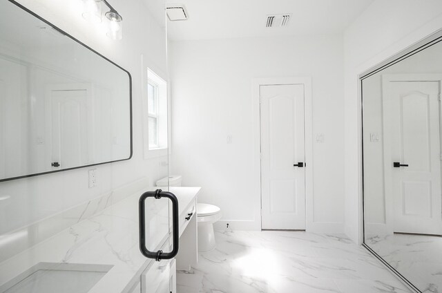 bathroom featuring marble finish floor, visible vents, baseboards, and toilet