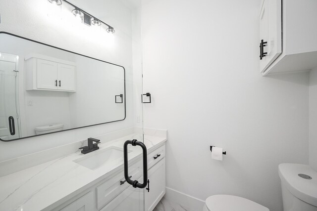 bathroom with toilet, marble finish floor, baseboards, and vanity