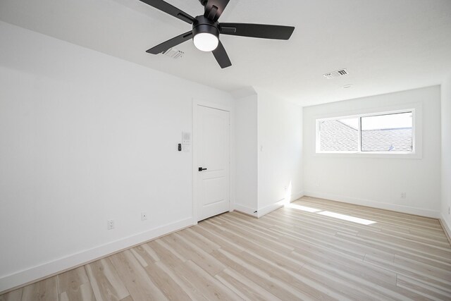 empty room featuring baseboards, visible vents, and light wood-style floors