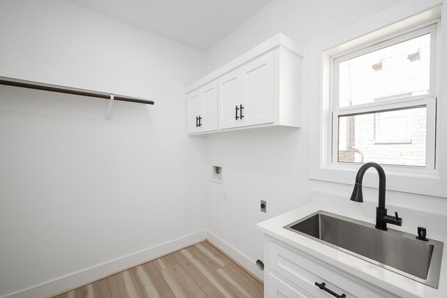 laundry area with baseboards, a sink, hookup for a washing machine, light wood-style floors, and electric dryer hookup