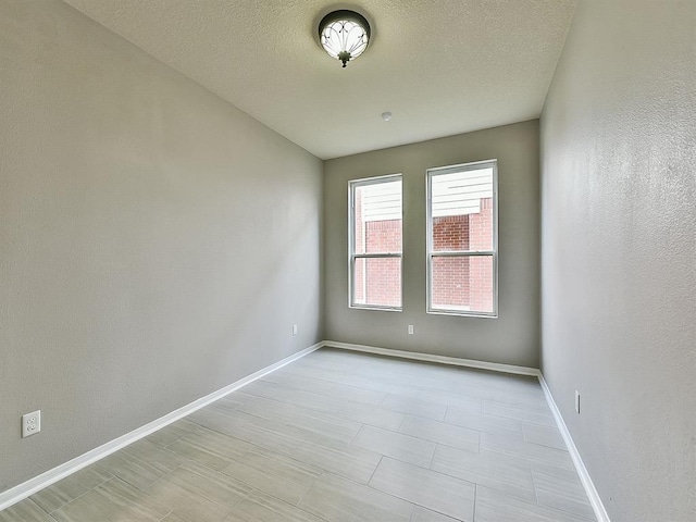 empty room with baseboards and a textured ceiling