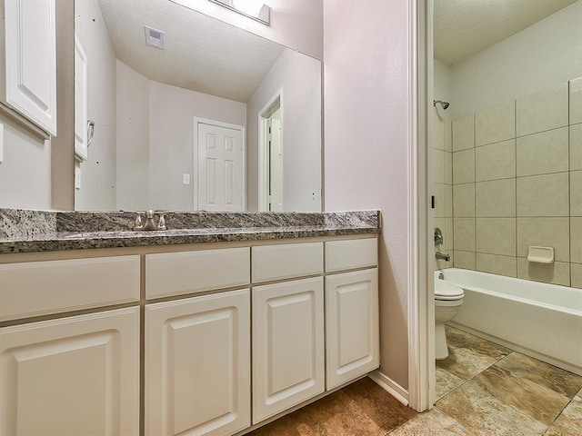 bathroom featuring visible vents, toilet, tub / shower combination, a textured ceiling, and vanity