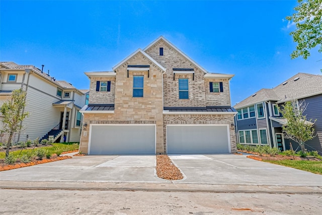 view of front of property featuring metal roof, concrete driveway, a standing seam roof, and an attached garage