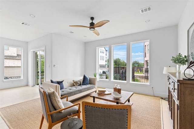 living room featuring wood finished floors, visible vents, and a ceiling fan