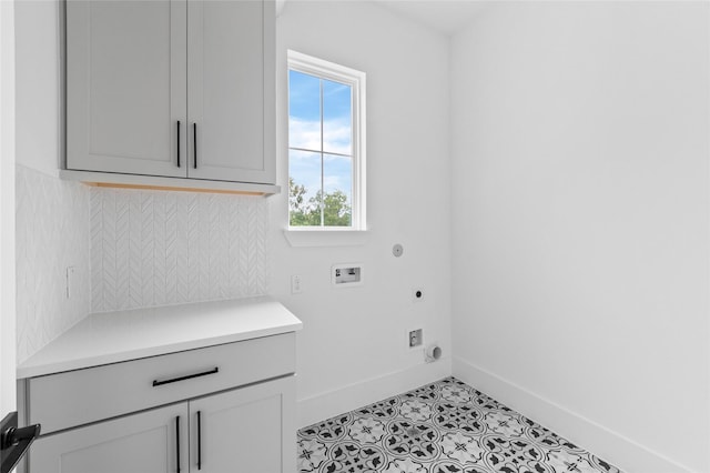 clothes washing area featuring cabinet space, baseboards, hookup for a washing machine, electric dryer hookup, and light tile patterned flooring