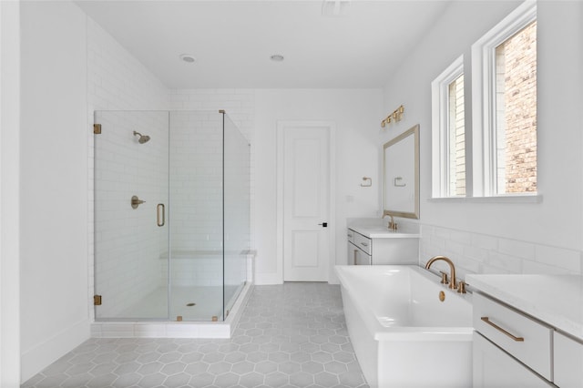 full bath featuring a soaking tub, a shower stall, vanity, and tile patterned floors