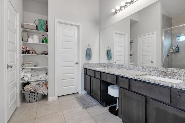 full bathroom featuring a spacious closet, a tile shower, and a sink