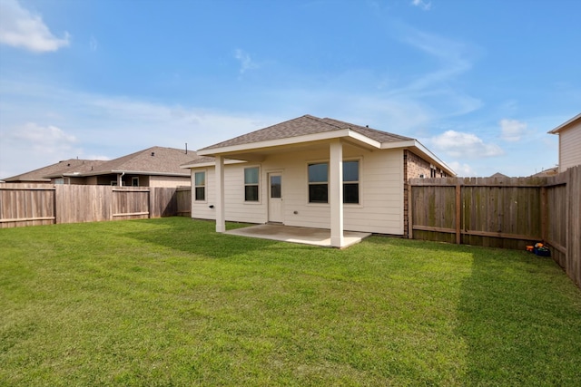 back of property with a fenced backyard, a lawn, and a patio