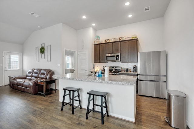 kitchen featuring appliances with stainless steel finishes, open floor plan, visible vents, and dark wood-style floors