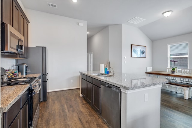 kitchen with visible vents, appliances with stainless steel finishes, vaulted ceiling, a sink, and an island with sink